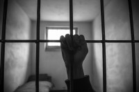 Hand on prison bars